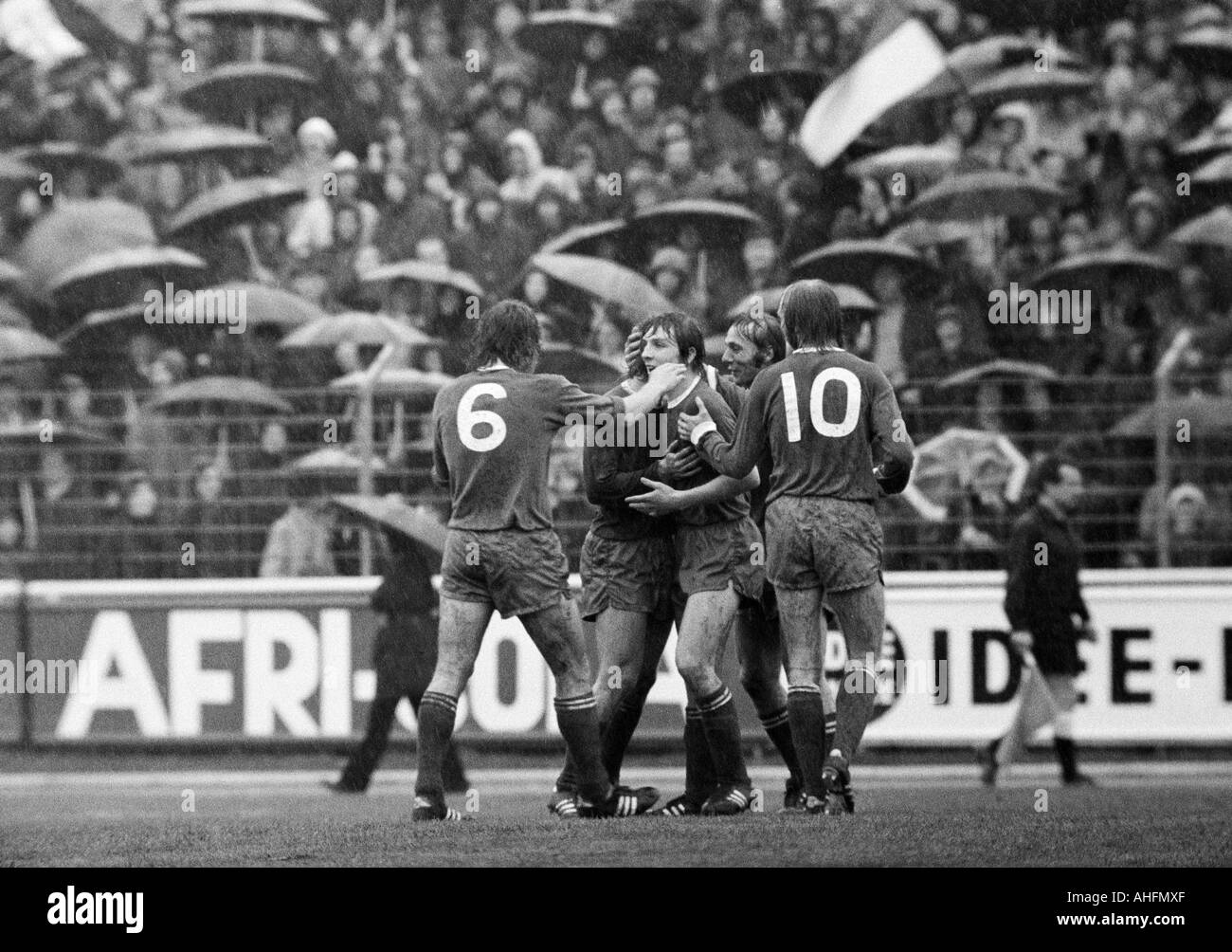 Fußball, Bundesliga, 1971/1972, Niederrhein-Stadion in Oberhausen, Rot-Weiss Oberhausen vs. FC Schalke 04 2:3, Regenwetter, Spiel bei starkem Regen, Zuschauer und Fußball-fans mit Sonnenschirmen, Spieler, die Freude am 0:1 Tor, v.l.n.r.: Herbert Luetkebo Stockfoto