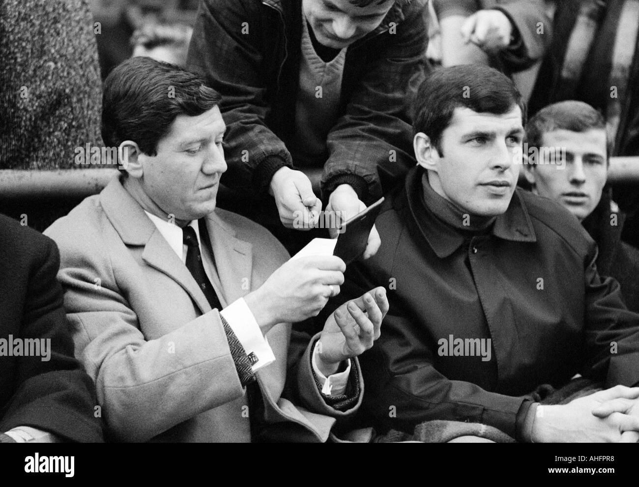 Fußball, Bundesliga, 1967/1968, FC Schalke 04 vs. 1. FC Köln 1:1, Glueckaufkampfbahn-Stadion in Gelsenkirchen, Besucher sitzen in den Stand Horst Szymaniak, Lothar Emmerich, Willi Neuberger Stockfoto