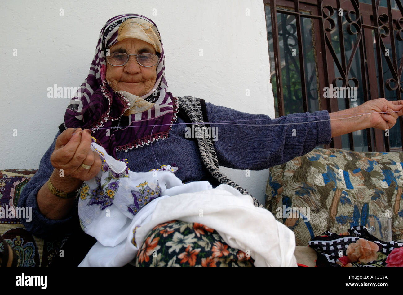 Türkische Frau sitzt auf ihrer Veranda Nähen und Sticken im Dorf Bezirgan in der Südtürkei. Stockfoto