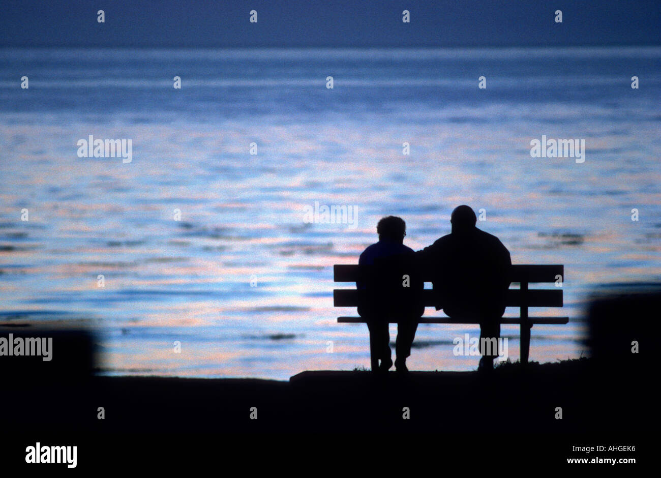 Ein paar sitzen auf einer Bank, Blick auf den Pazifischen Ozean Stockfoto