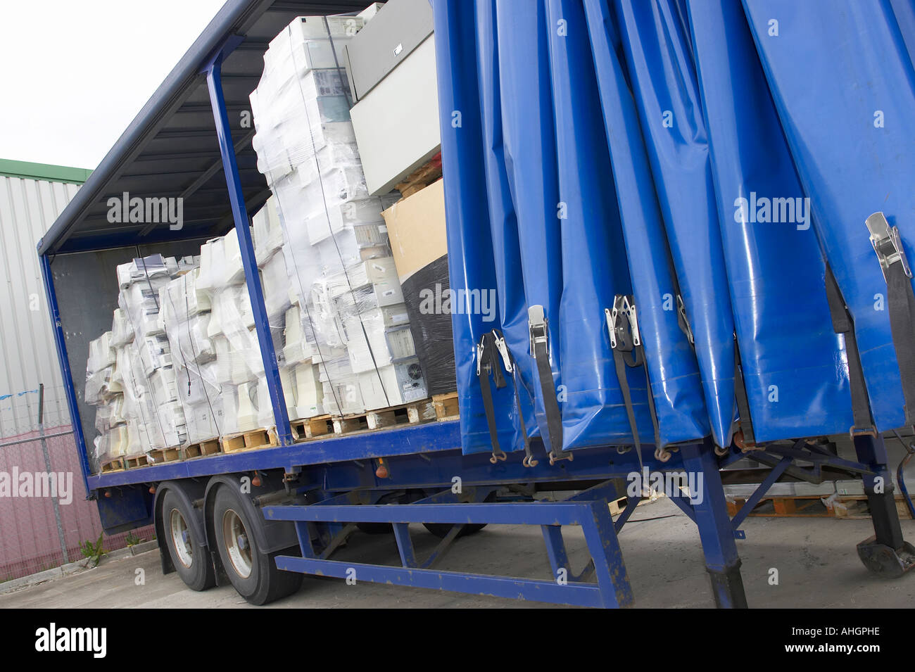 Offene Seite des blauen Vorhang LKW Anhänger mit Paletten verpackt Computermonitoren und Systemboxen für das recycling Stockfoto
