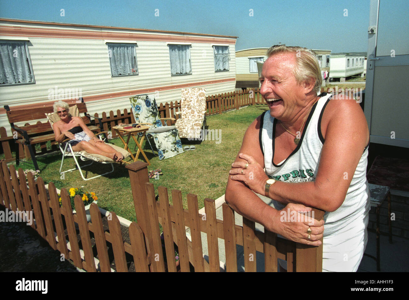 Älteres Paar zum Entspannen in der Sonne draußen ihre statische Wohnwagen bei Trecco Bay Porthcawl South Wales UK Stockfoto