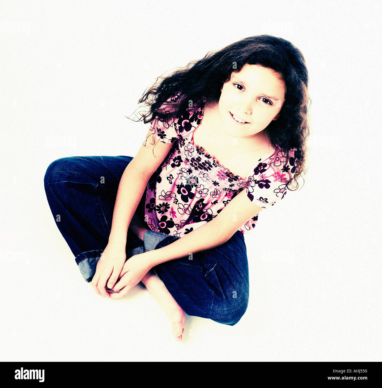 Mädchen saß Schneidersitz am Boden weißen Hintergrund Stockfoto