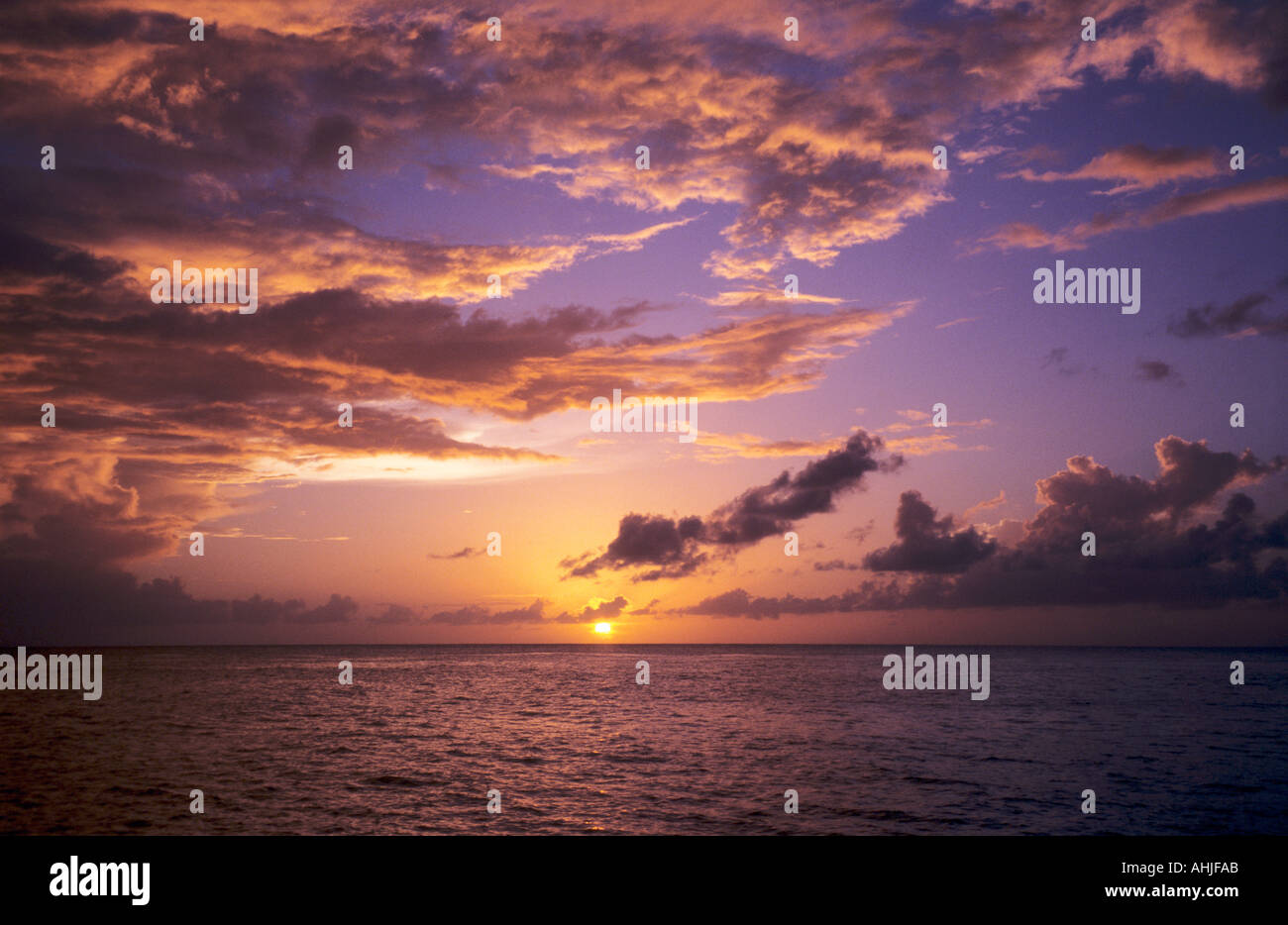 Blick auf das Meer bei Sonnenuntergang mit goldenen, gelben und orangen Wolken und Himmel. St. Lucia. Stockfoto