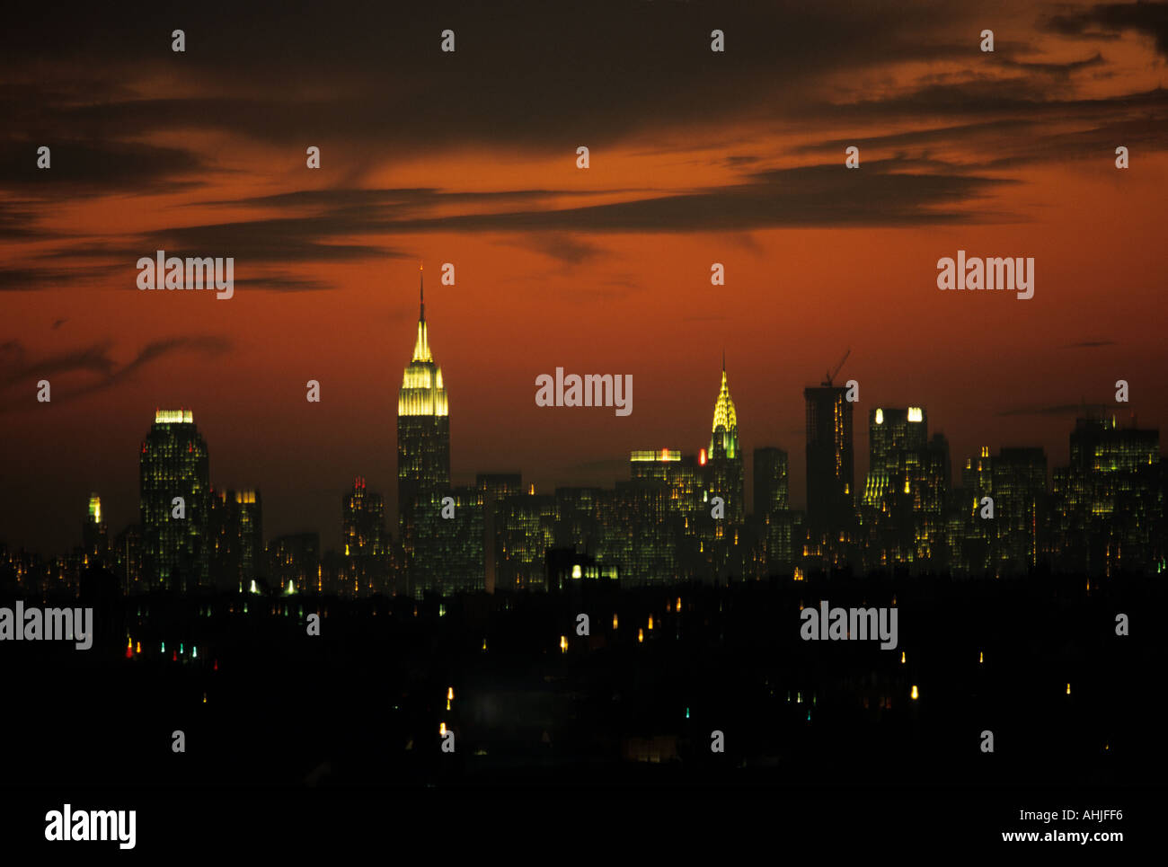 Skyline von Uptown Manhattan mit Empire State Building und Chrysler Building bei Sonnenuntergang mit orangefarbenem Himmel. New York, New York, USA. Stockfoto