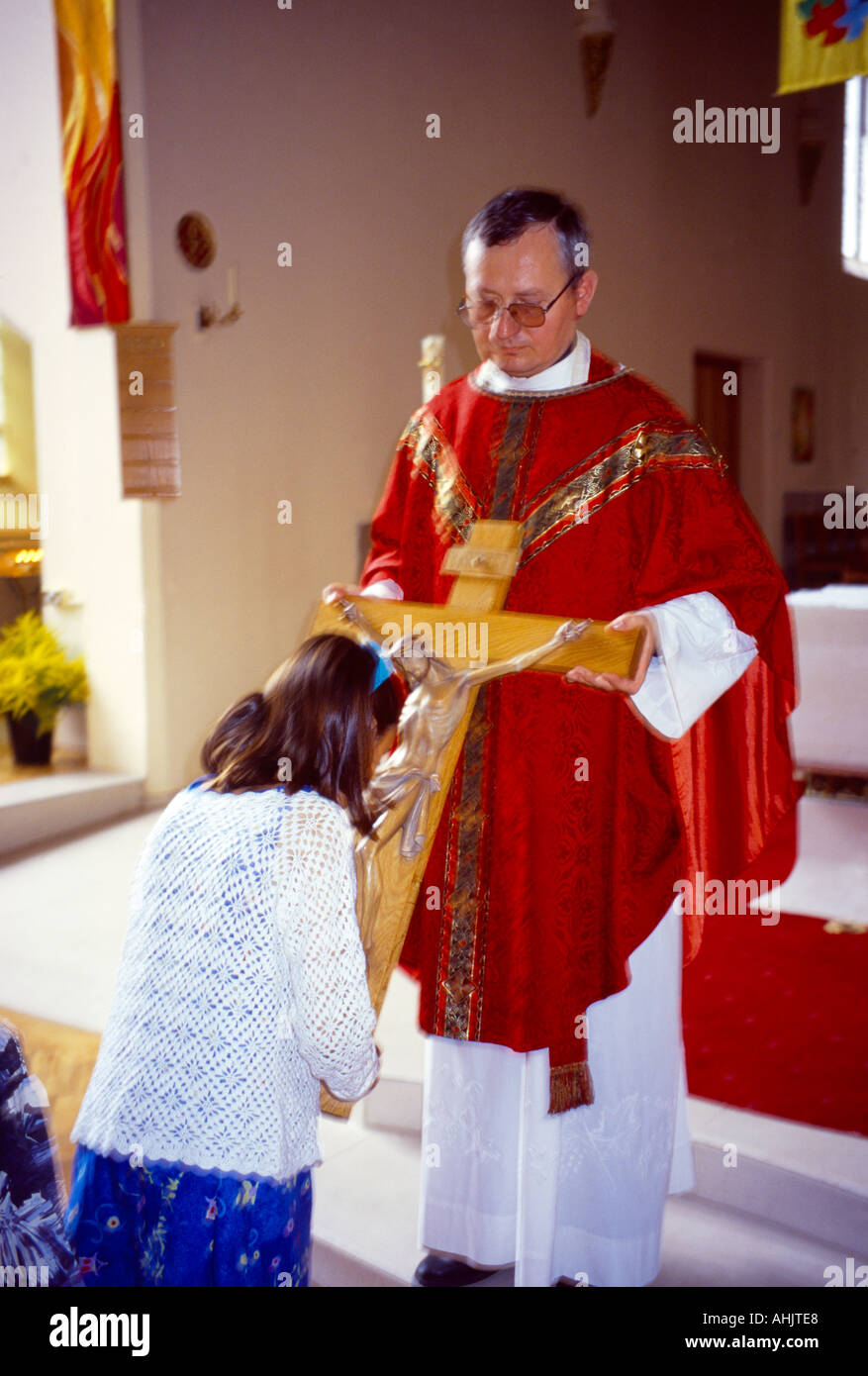 St. Joseph Kirche küssen Kreuz an Ostern Priester In rot Stockfoto
