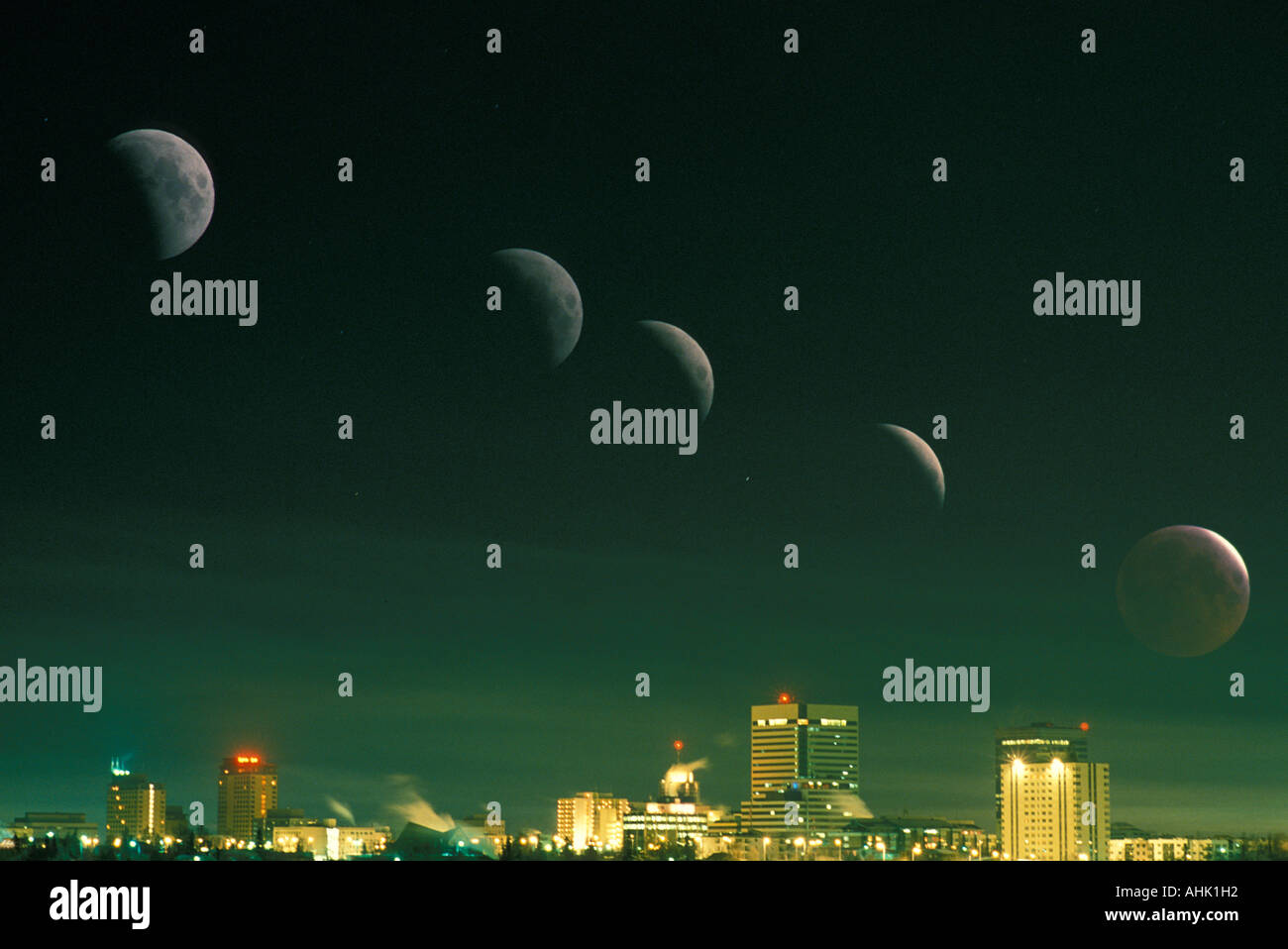 USA Alaska Anchorage Mehrfachbelichtung der Mondfinsternis über die Skyline der Stadt auf Winternacht Stockfoto