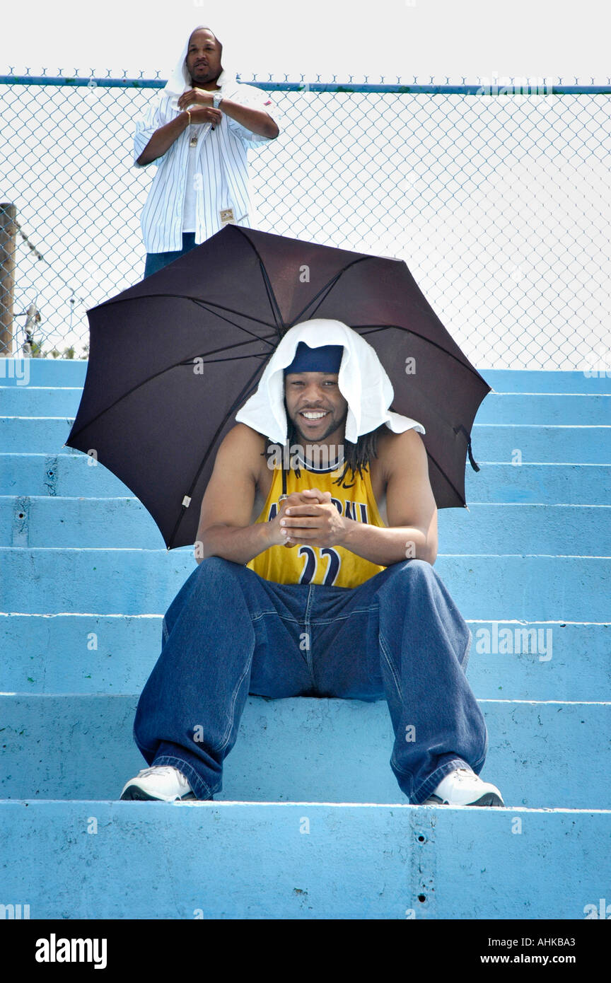 Mann aus der heißen Sonne im Süden mit Regenschirm auf 100 Grad am Tag bleiben Stockfoto
