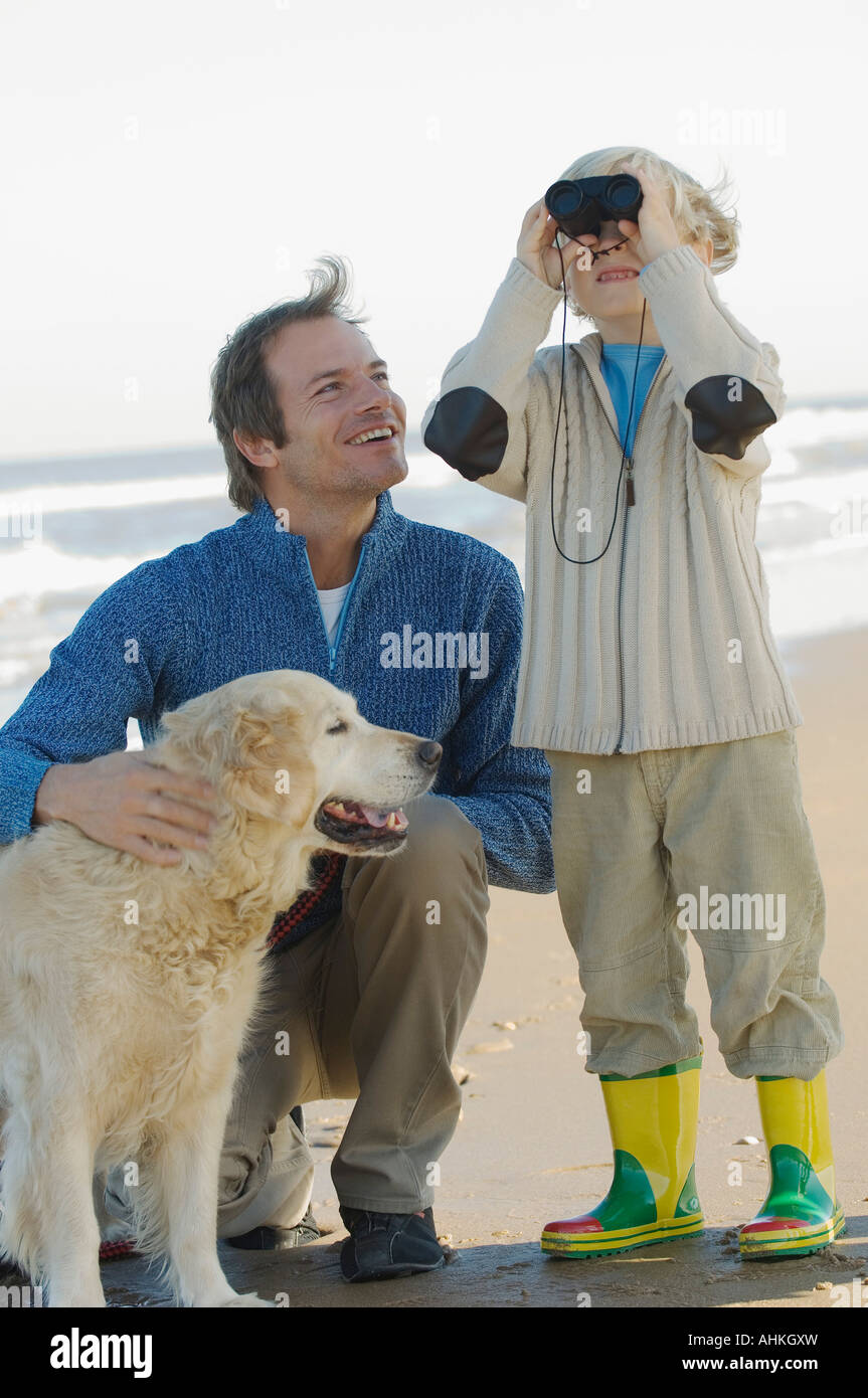 Vater und Sohn mit ihrem Hund am Strand Stockfoto