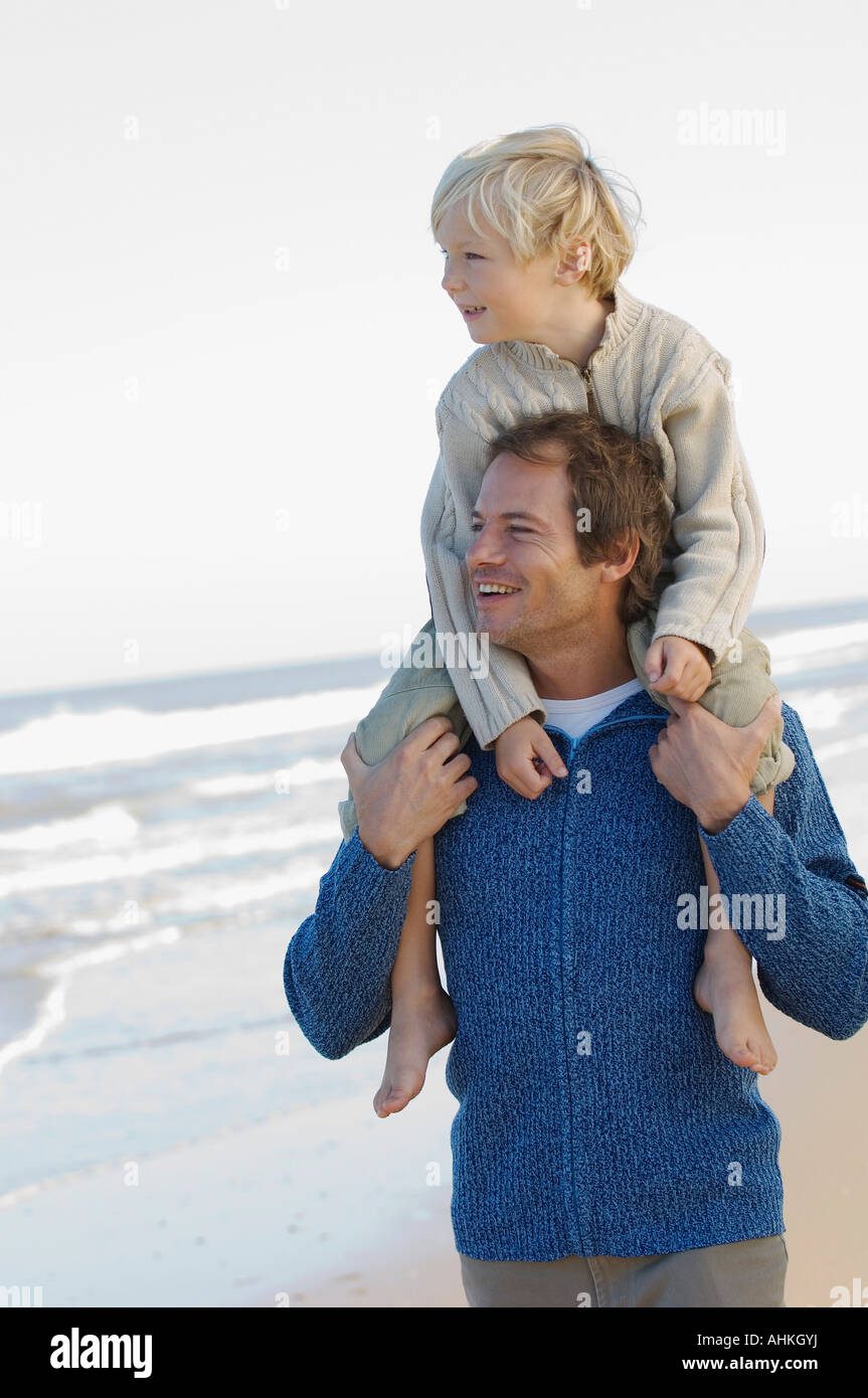 Vater mit Sohn Huckepack am Strand Stockfoto
