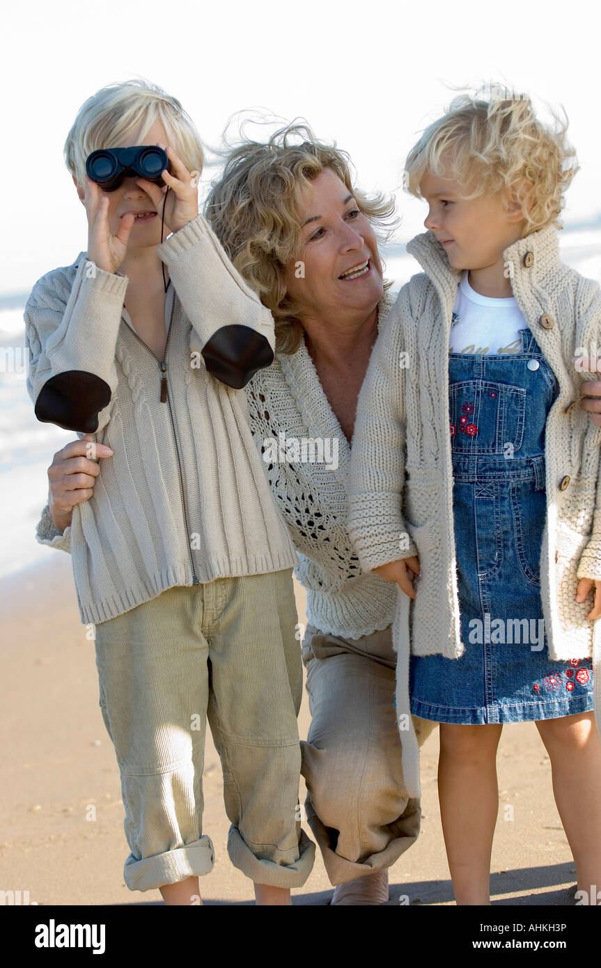 Großmutter mit Kindern am Strand Stockfoto