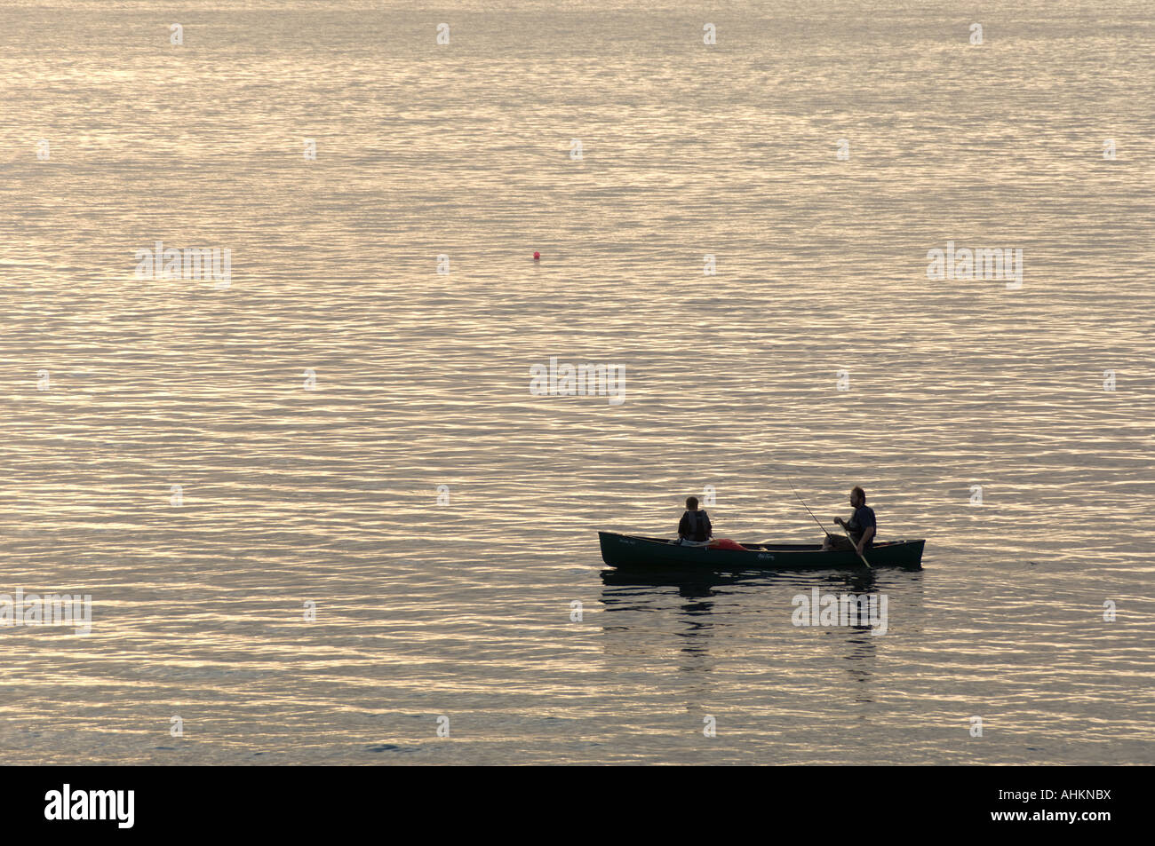 zwei Männer Angeln allein im Kanu auf dem Meer - Cardigan Bay - Aberystwyth bei Sonnenuntergang Sonnenuntergang Abend Stockfoto