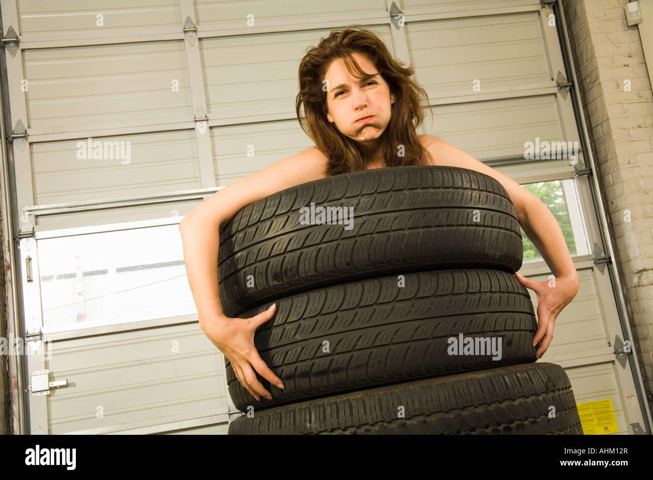 Nackte Frau im Stapel von Reifen Stockfotografie Alamy