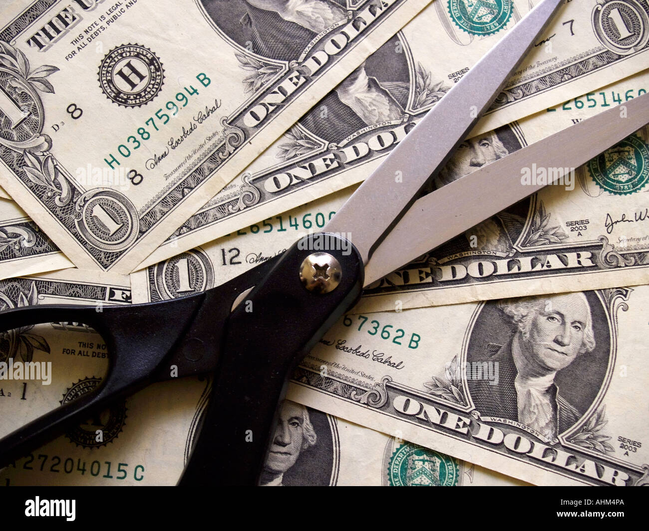 Geschärfte schwarz behandelt Schere vor dem Hintergrund einer Dollar-Scheine Stockfoto