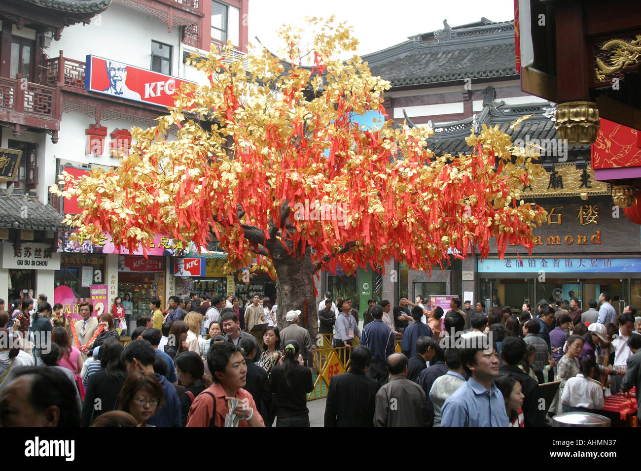 Drängen Sie sich in Shanghai, Chinai, um einen Wunschbaum mit goldenen Blättern und roten Bändern Stockfoto