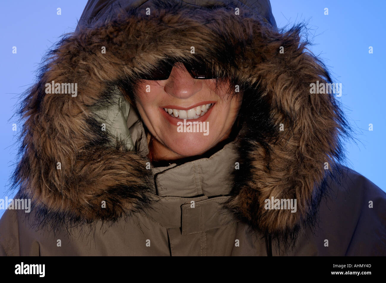 Frau trägt einen Parka Mantel und Sonnenbrille Stockfoto