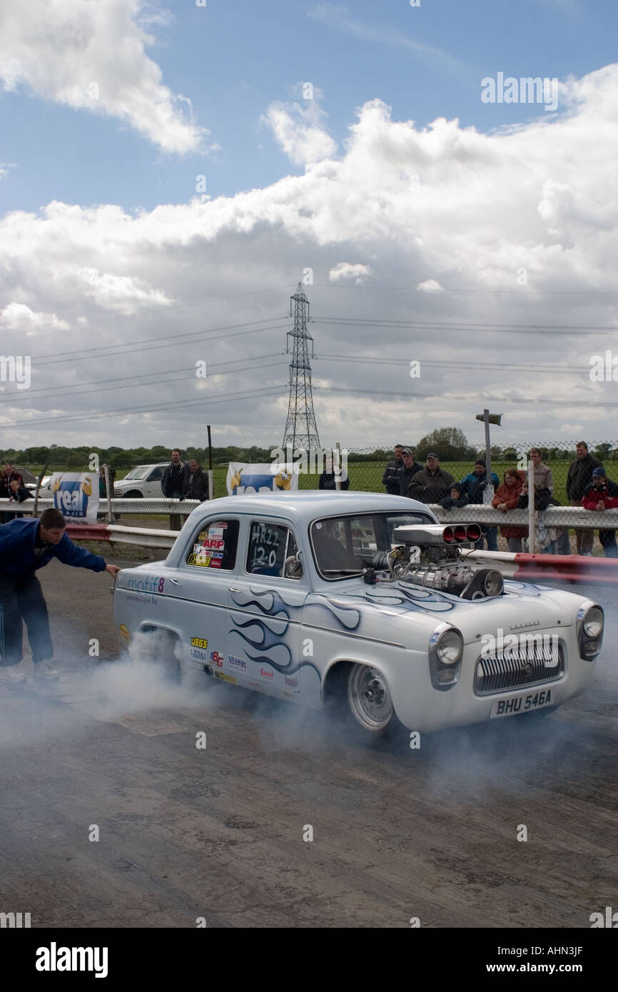 Stark modifizierte Ford Anglia beliebt machen einen Burnout beim Drag-Rennen Stockfoto