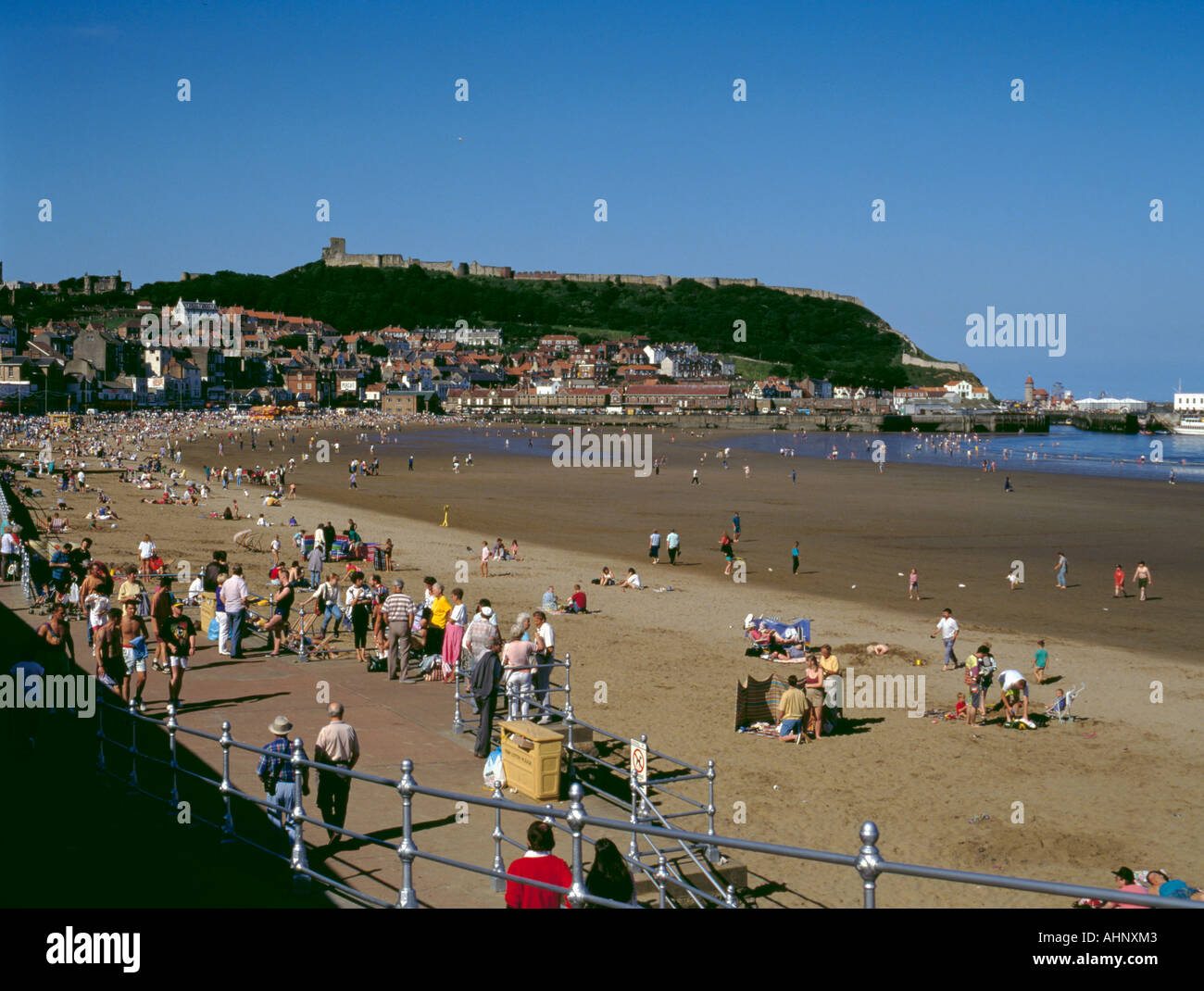 South Bay Strand an einem Sommertag mit Scarborough Castle und Hafen über Scarborough, North Yorkshire, England, UK Stockfoto