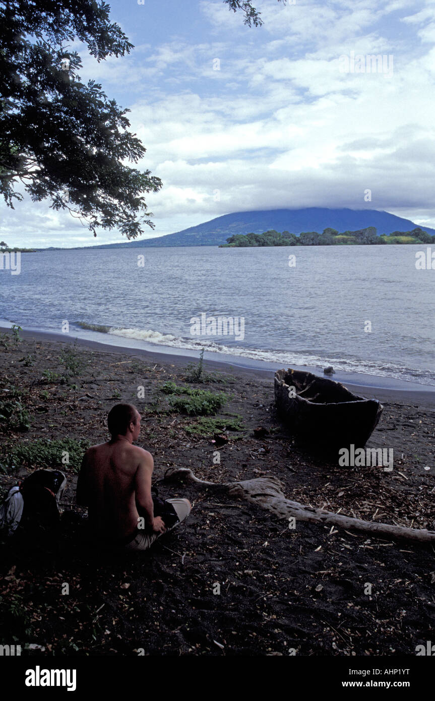 Männliche Touristen sitzen auf einem felsigen Strand, Isla de Ometepe oder Insel Ometepe, Nicaragua Stockfoto