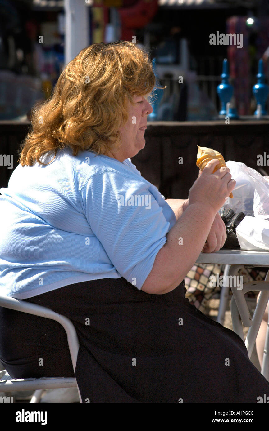 Übergewichtige Erwachsene weibliche sitzen eine doppelte Eis essen. Stockfoto