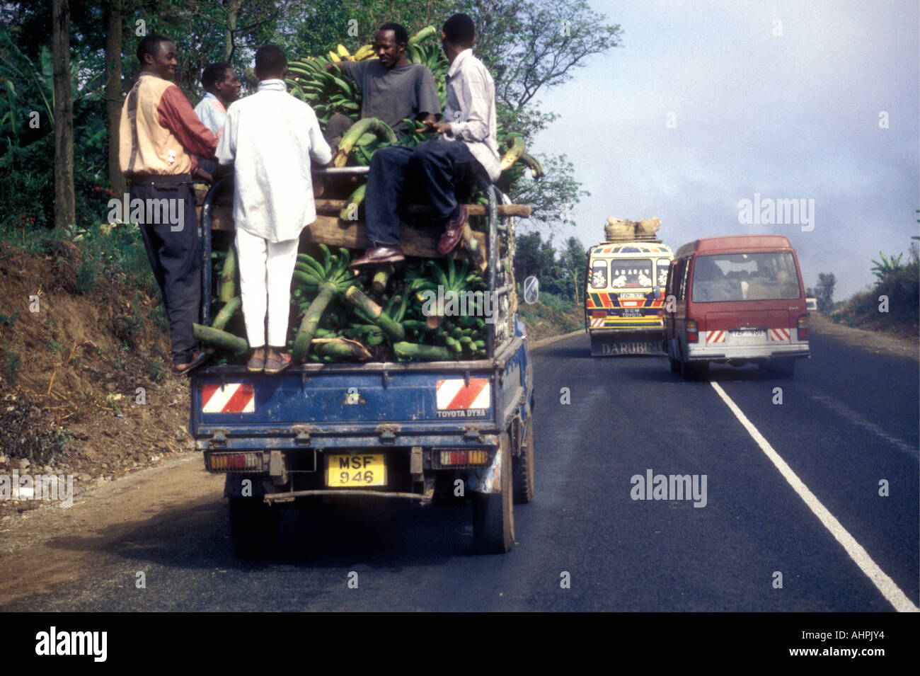 LKW schwer beladen mit Bananen und Arbeiter auf der Hauptstraße in Arusha Tansania Ostafrika abholen Stockfoto