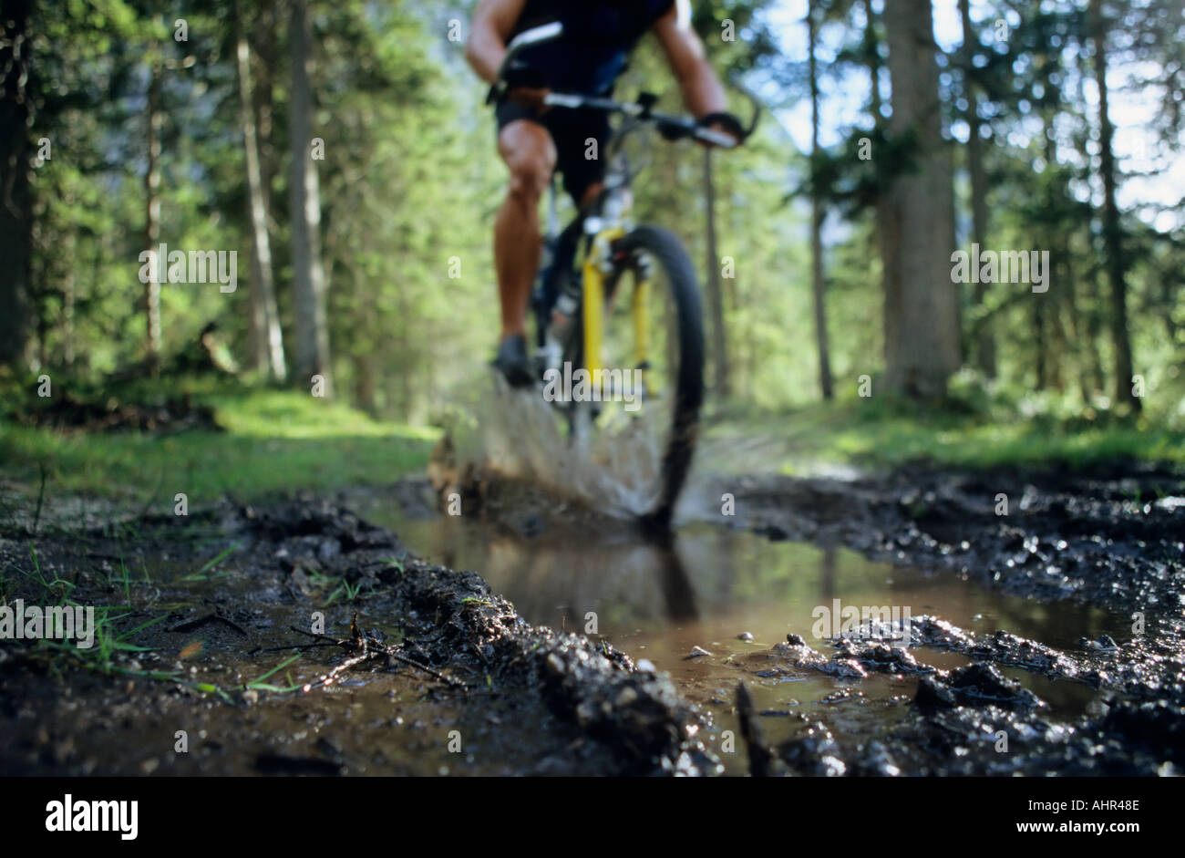 Eine Person, die durch eine Pfütze Radfahren Stockfoto