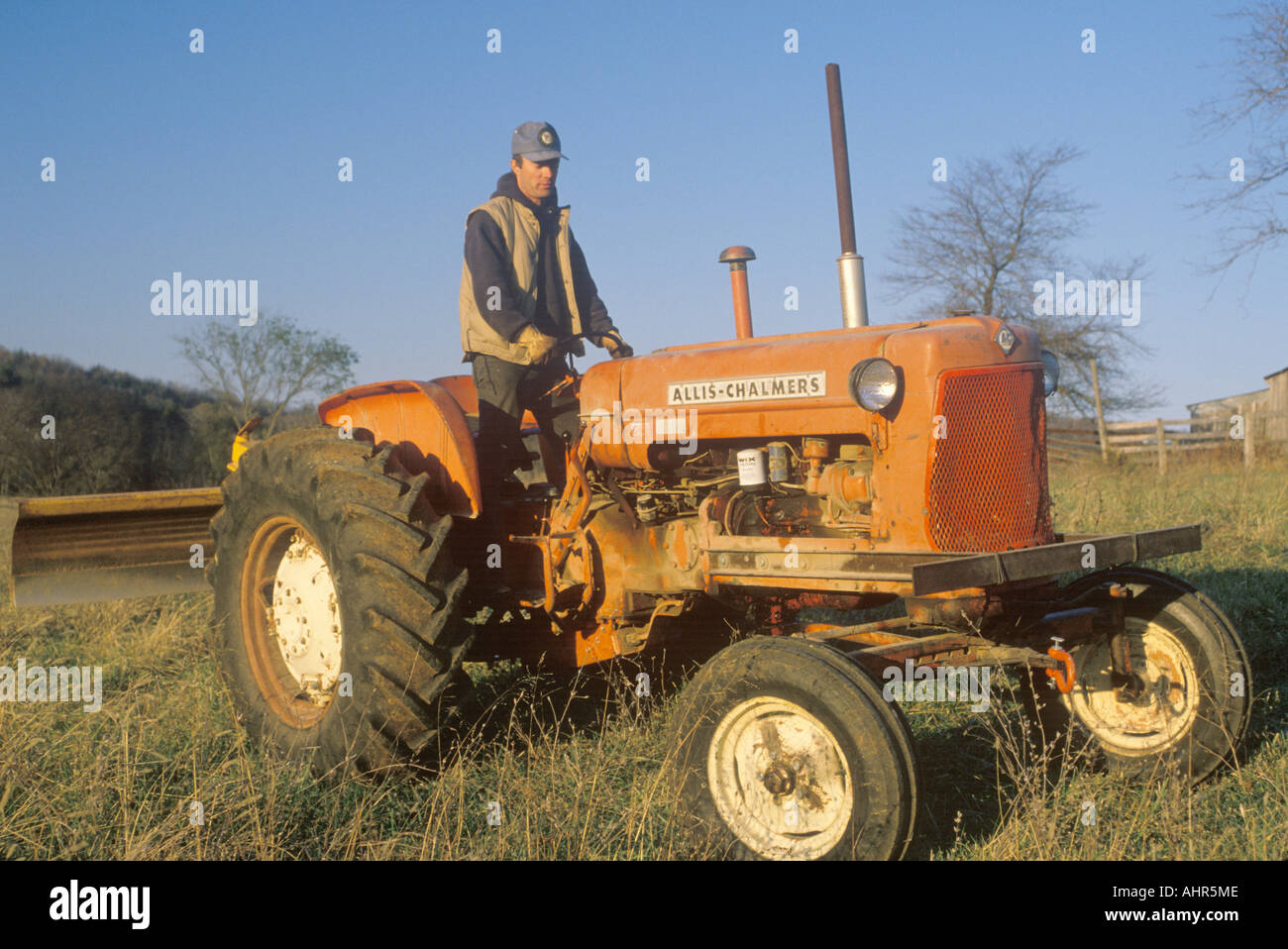 Bauer stand auf Traktor auf Rinderfarm in Bourbon MO Stockfoto
