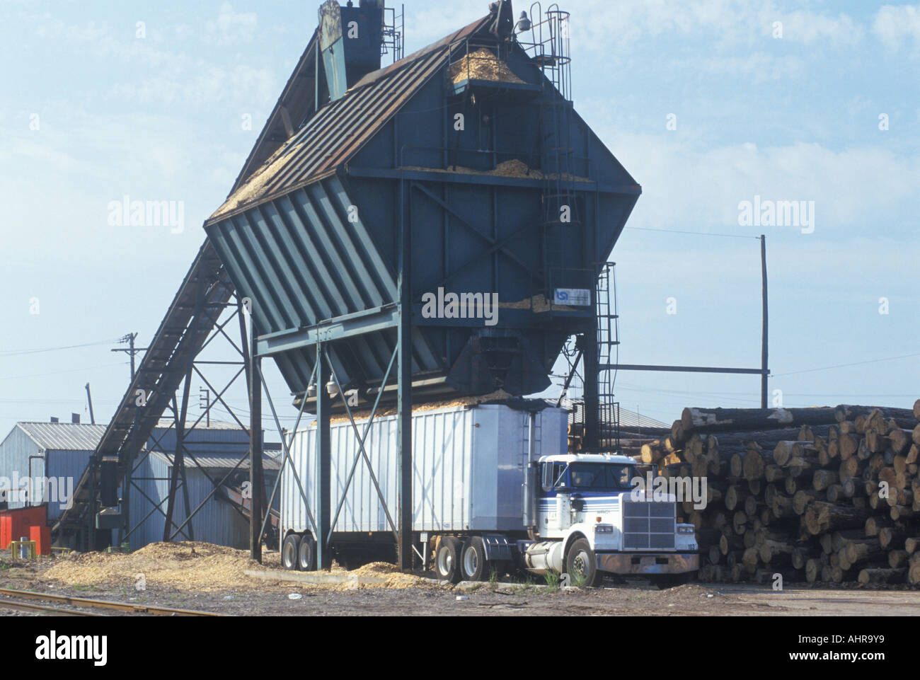 Sägemehl und Hackschnitzel werden in einem großen Lastwagen in einer Papierfabrik geladen. Stockfoto
