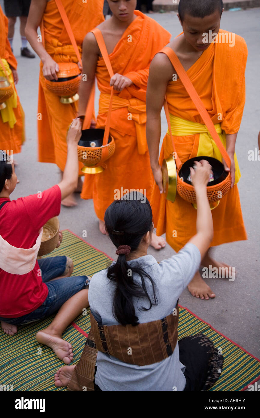 Einheimische Frauen geben klebrigen Reis als Almosen für Mönche in Luang Prabang Laos Stockfoto