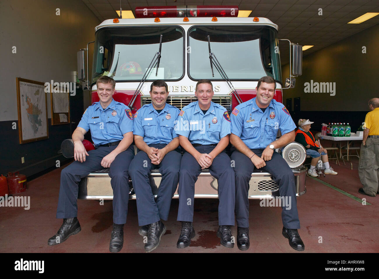 Vier Feuerwehrleute sitzen auf der Vorderseite des Feuerwehrauto in Americus Georgia Stockfoto