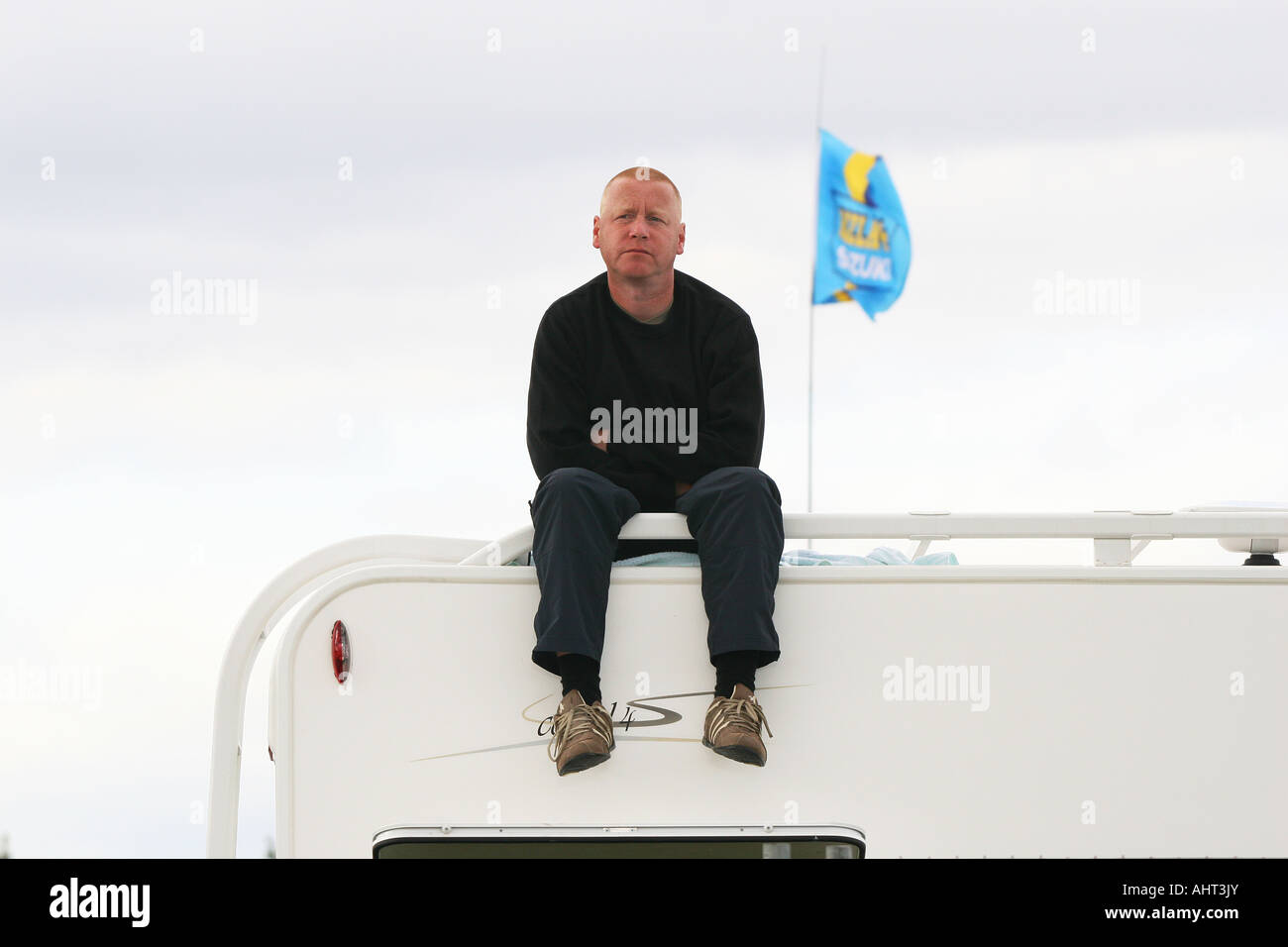 Mann sitzt auf Camper Dach beobachten Rennen in Cadwell Park. Stockfoto