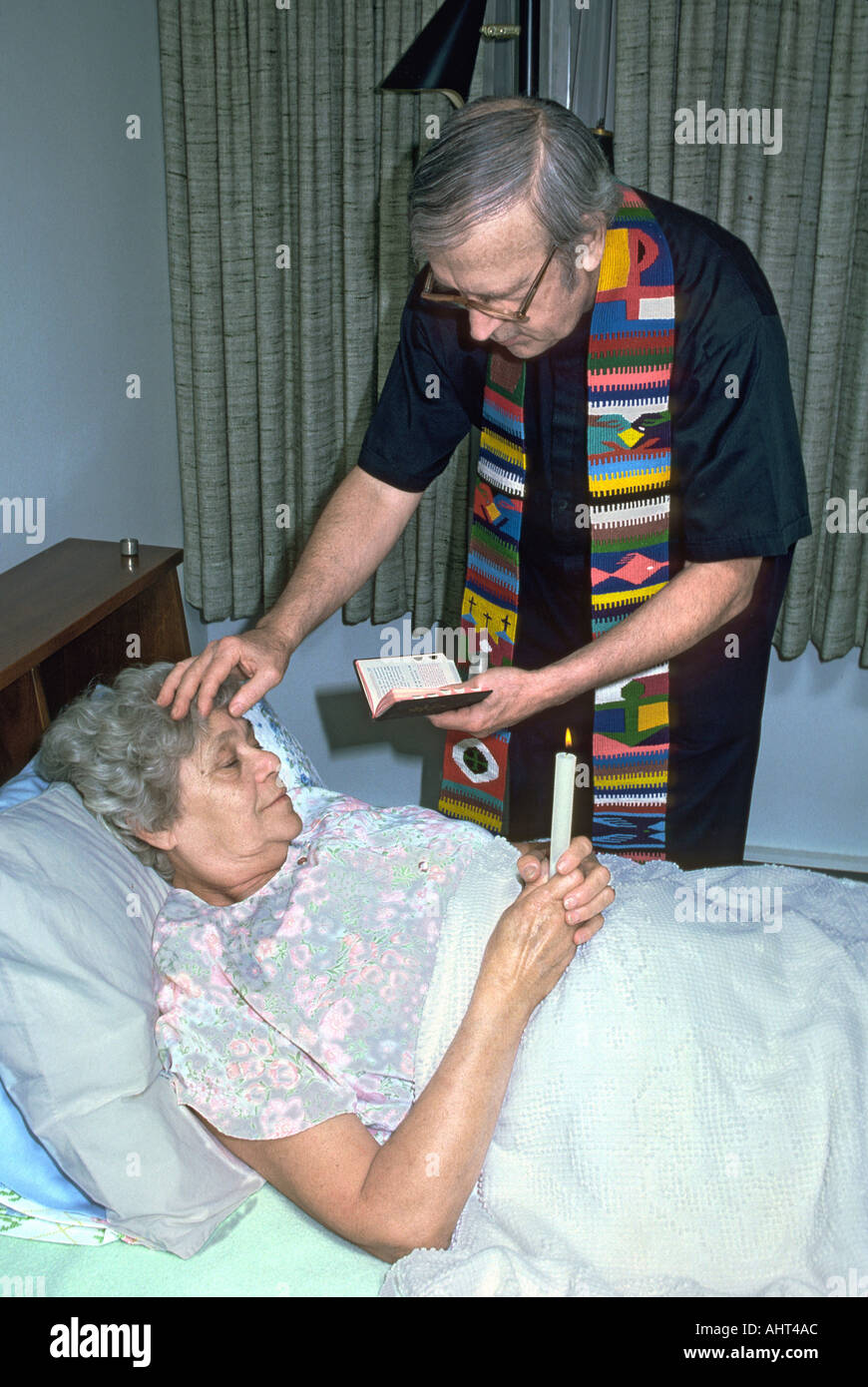 Katholische Priester verwaltet die letzte Ölung zu älteren senior weiblich Stockfoto