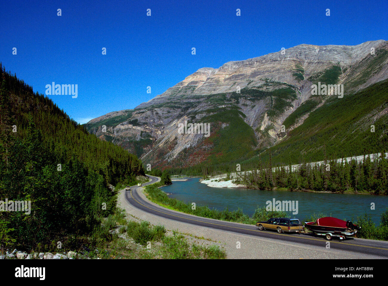 Alaska Highway entlang Racing River und nördlichen Rocky Mountains, British Columbia Kanada - betritt Schwemmfächer Fluss hinter Bäumen Stockfoto