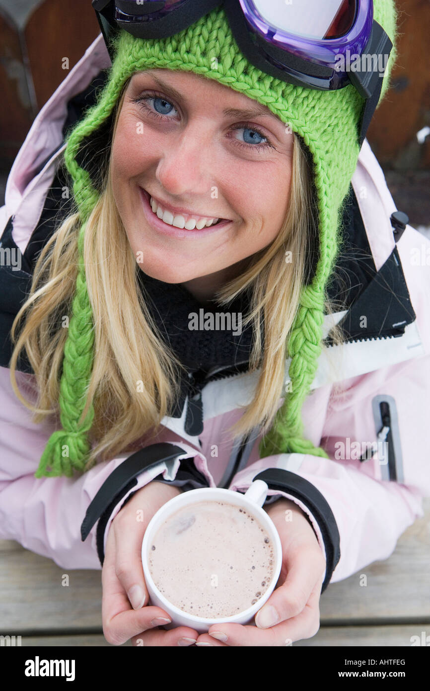Junge Frau in Skibekleidung mit Tasse heiße Schokolade, Nahaufnahme, Vogelperspektive, Porträt Stockfoto