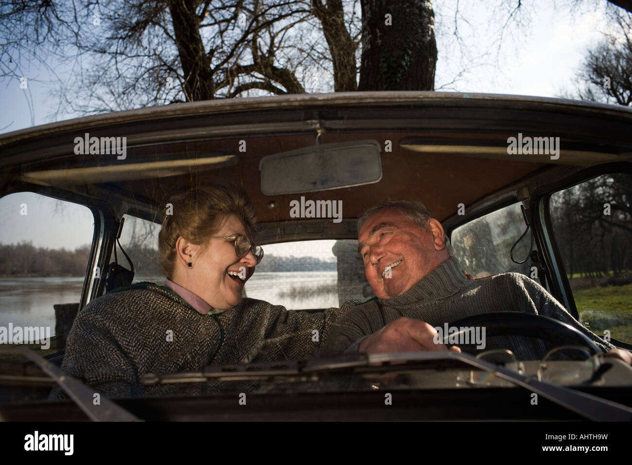 Älteres Paar, sitzen im Auto, Lächeln einander an Stockfoto