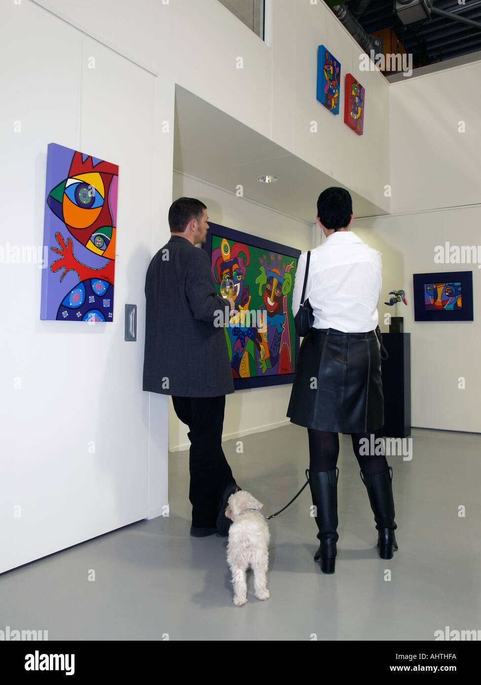 Paar mit kleinen Hund in einer Kunstgalerie mit moderner Kunst des niederländischen Künstlers Marianne Naerebout Breda, Niederlande Stockfoto