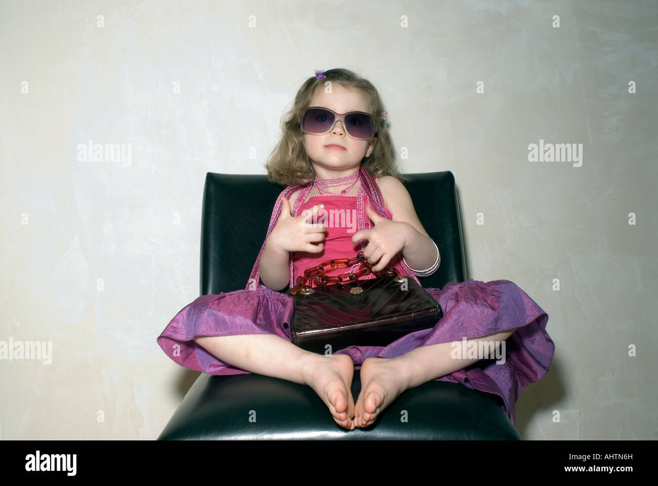 Mädchen (2-4) im sitzen mit Handtasche Party-Kleidung. Stockfoto
