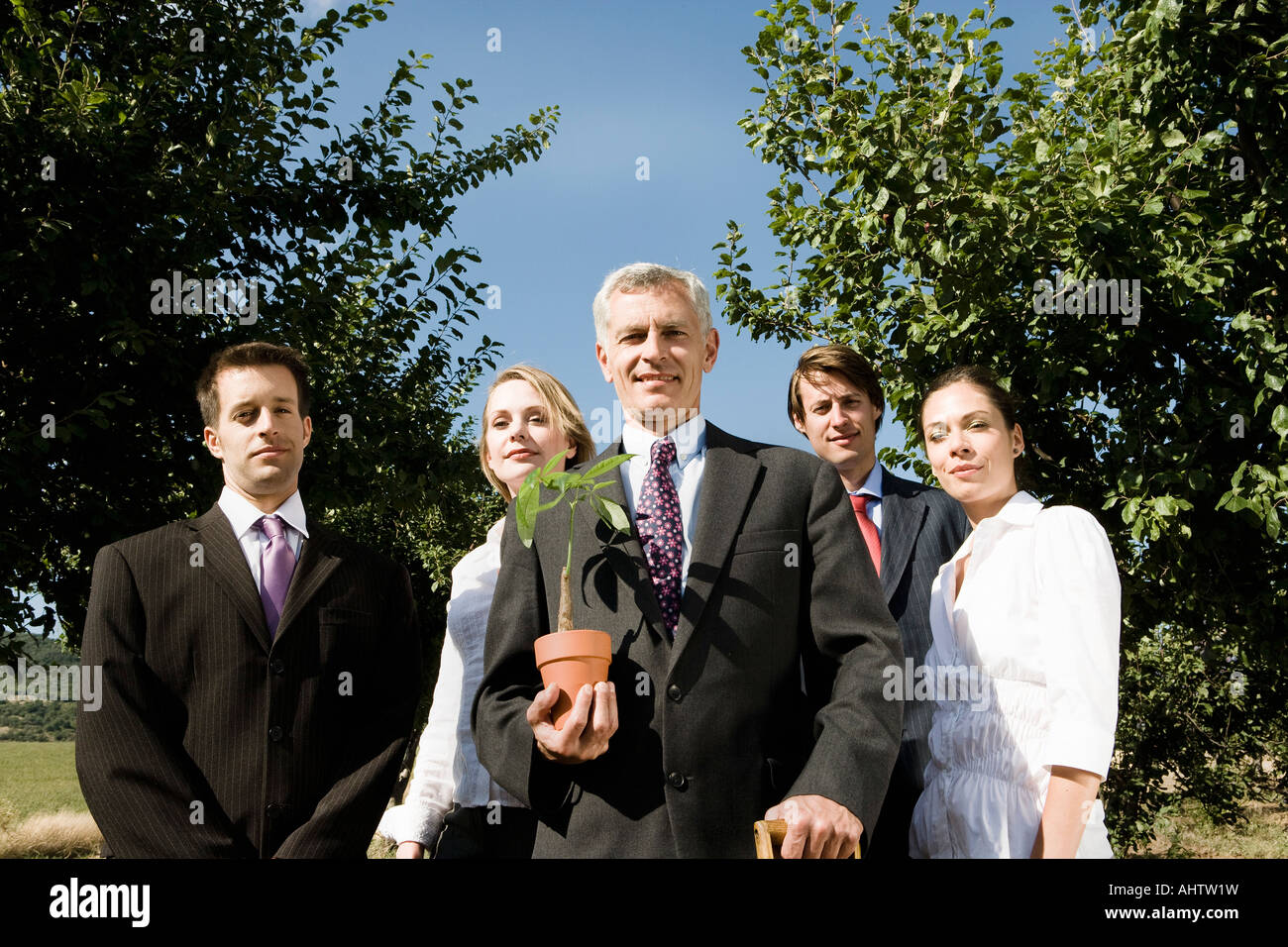 Gruppe von Geschäftsleuten in einem Obstgarten. Stockfoto