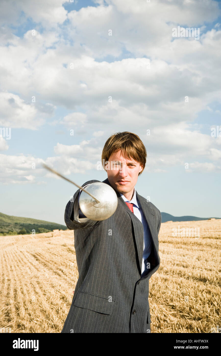 Geschäftsmann Fechten im Weizenfeld. Stockfoto