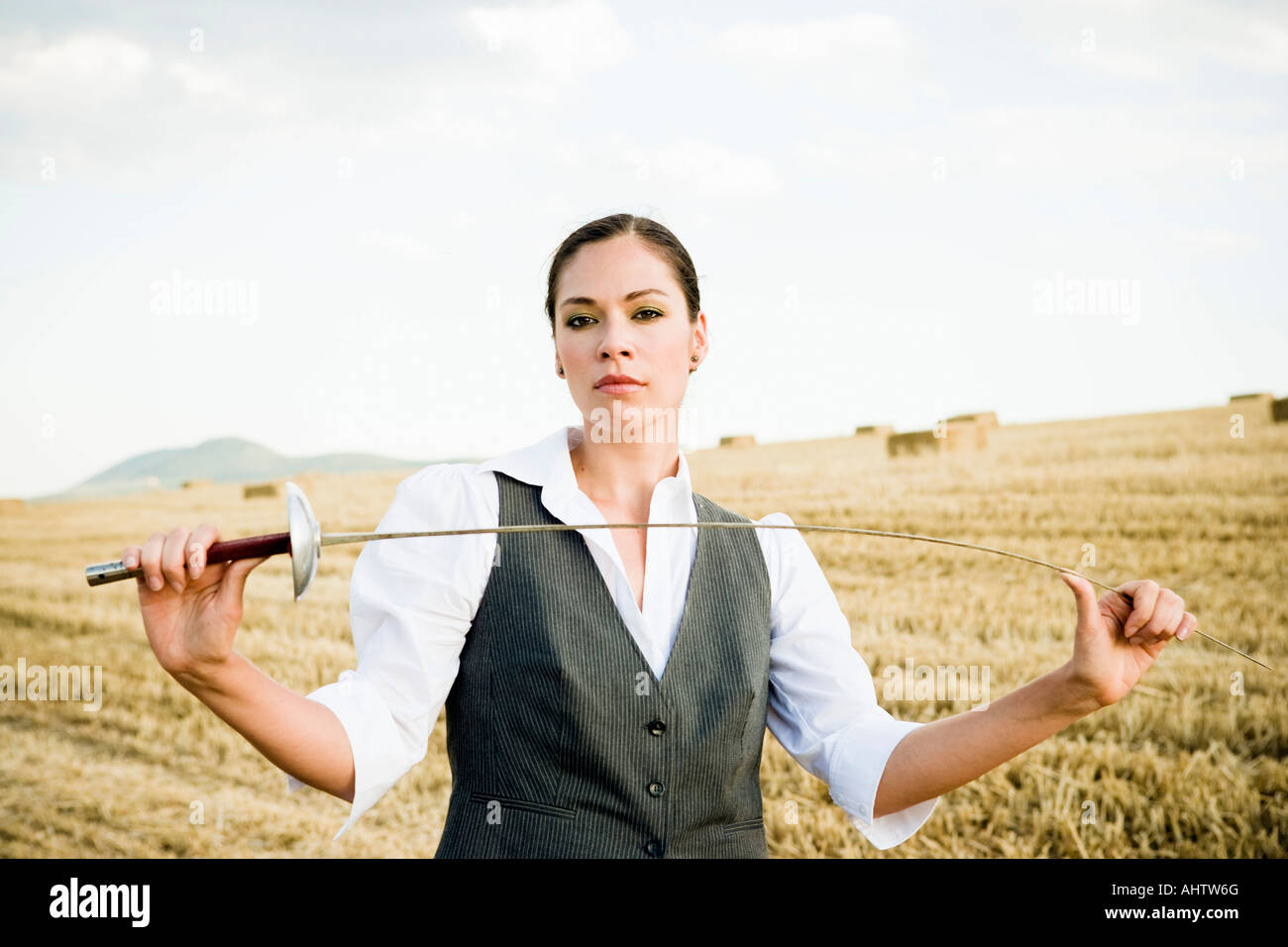 Geschäftsfrau Fechten in einem Weizenfeld. Stockfoto