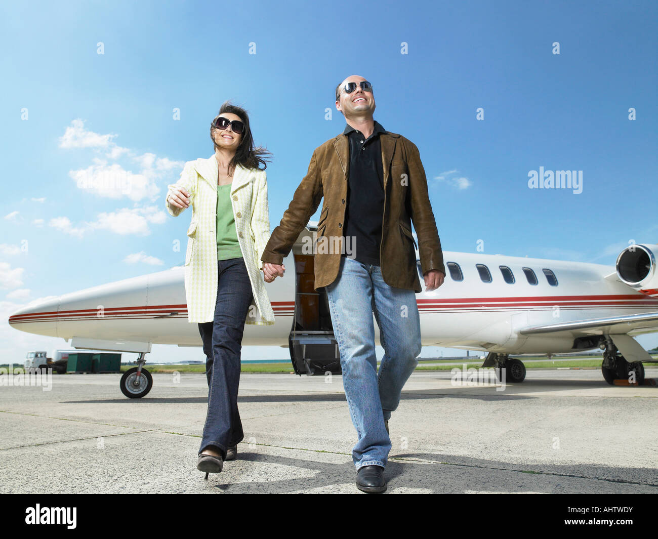 Glückliches Paar zu Fuß entfernt von privat-Jet. Stockfoto