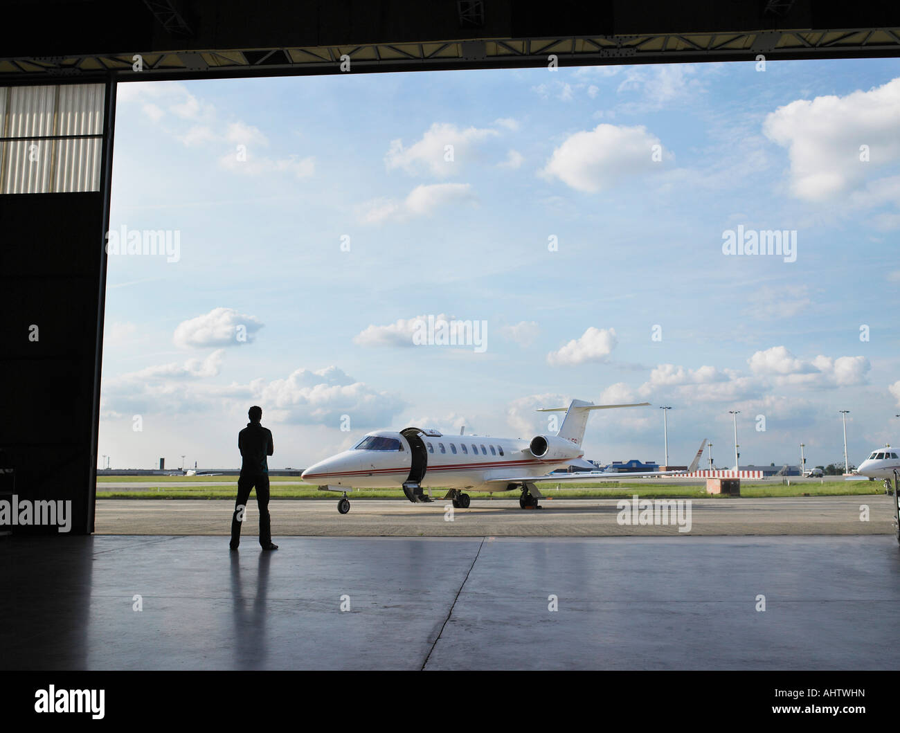 Techniker im Hangar Privatjet auf Asphalt zu betrachten. Stockfoto