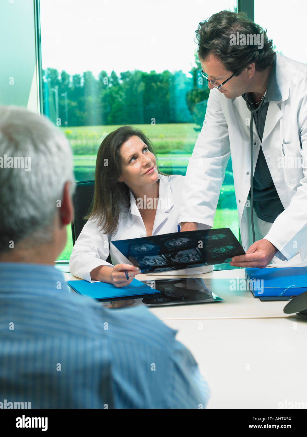 Zwei Ärzte Röntgen mit mündige Patient zu diskutieren. Stockfoto