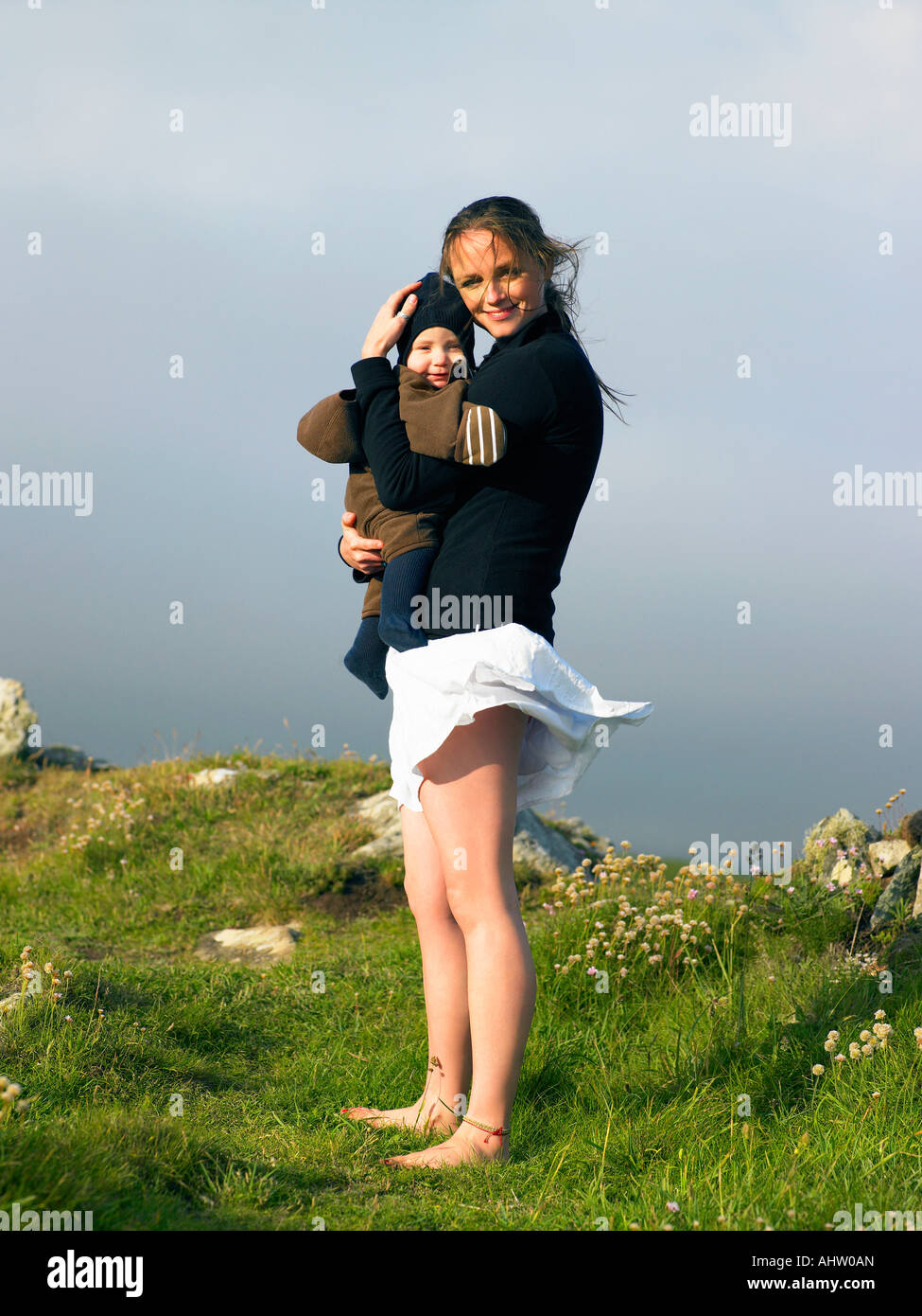 Junge Frau halten Baby mit dem Wind ihren Rock hoch. Stockfoto