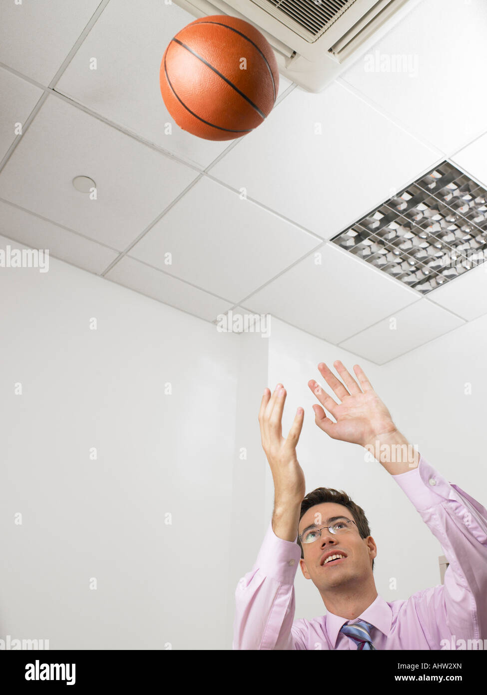 Geschäftsmann in einem Büro werfen einen basketball Stockfoto