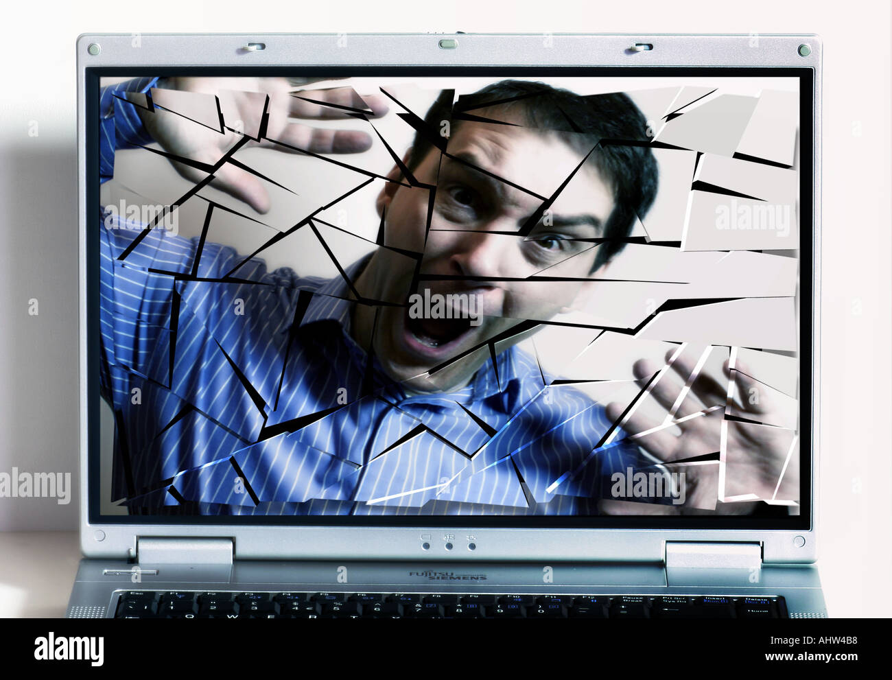 Komposit zeigt Mann Angst hinter zerbrochenen Notebook-Bildschirm Stockfoto