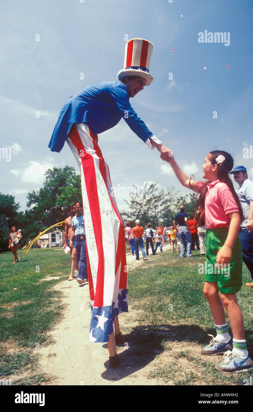 Mann auf Stelzen gekleidet wie Uncle Sam schütteln Mädchen s Hand Salina Kansas Stockfoto