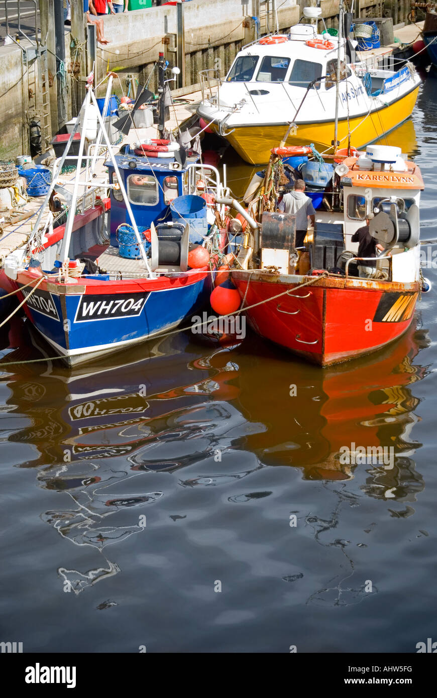 Vertikale Ansicht von zwei bunte Fischerboote vertäut im 17. Jahrhundert alten Hafen von Weymouth. Stockfoto