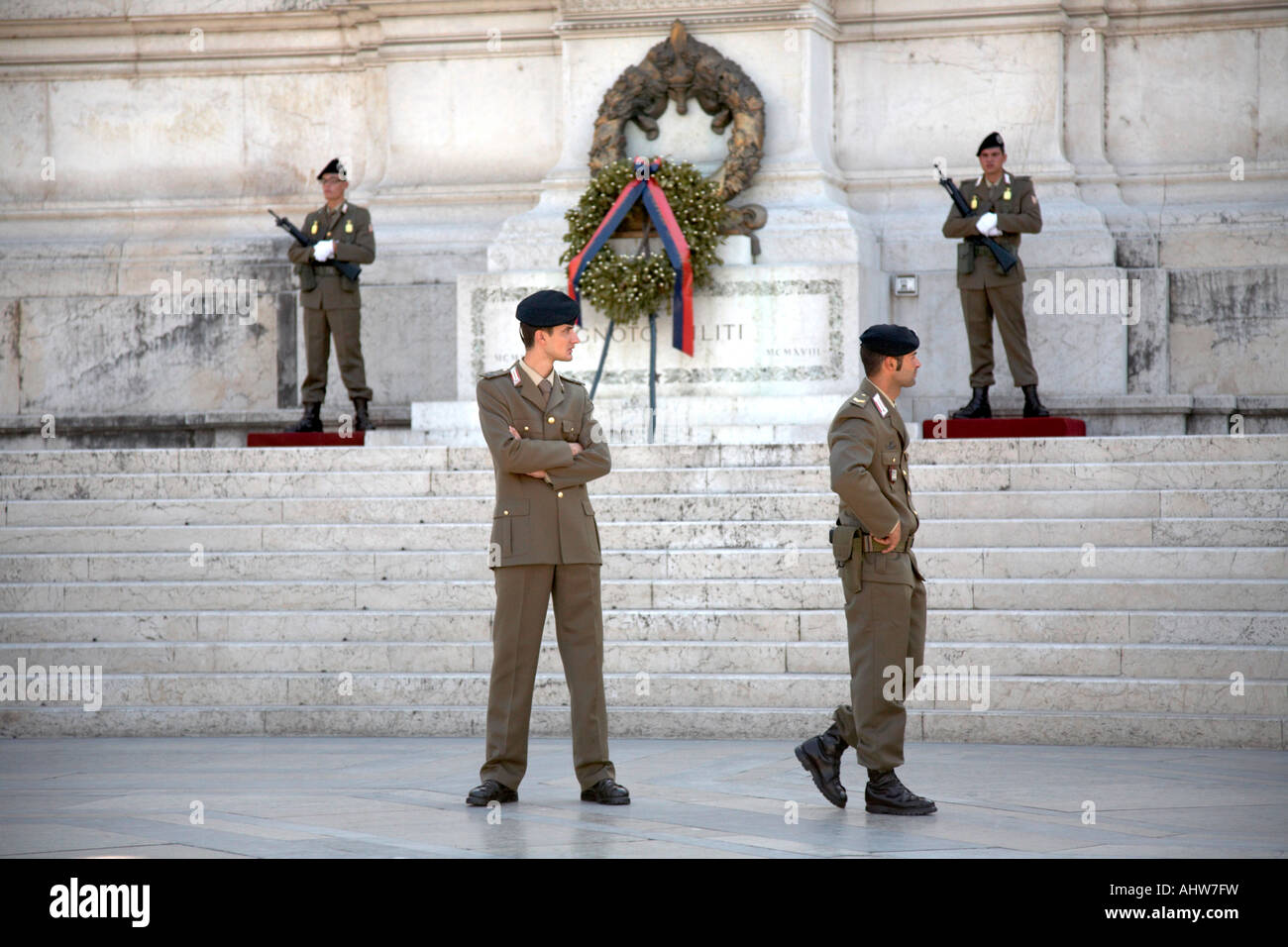 Offiziere der italienischen Armee bewachen die Kränze und ewigen Flammen als zwei andere Offiziere Patrouille am Denkmal Vittorio Emanuele II Stockfoto