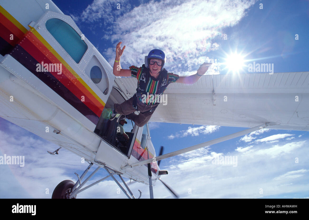 Fallschirmspringer in Streetwear einen Sprung von einer Pilatus Porter Aircraft mit Sonne im Hintergrund Stockfoto